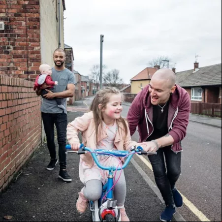 Two people walking down the street with children