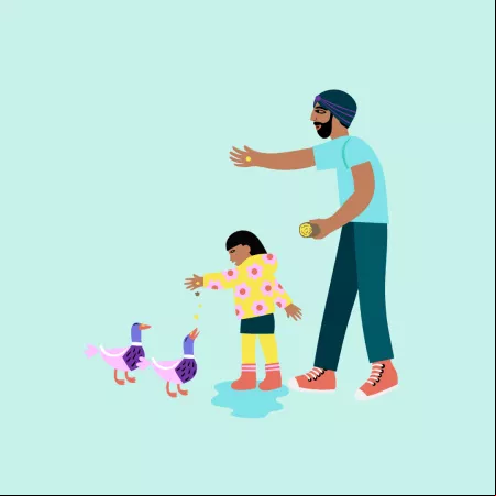 Dad feeding ducks with child