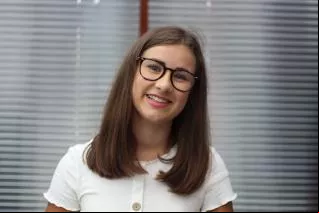 Georgina Vine, smiling with glasses and white top